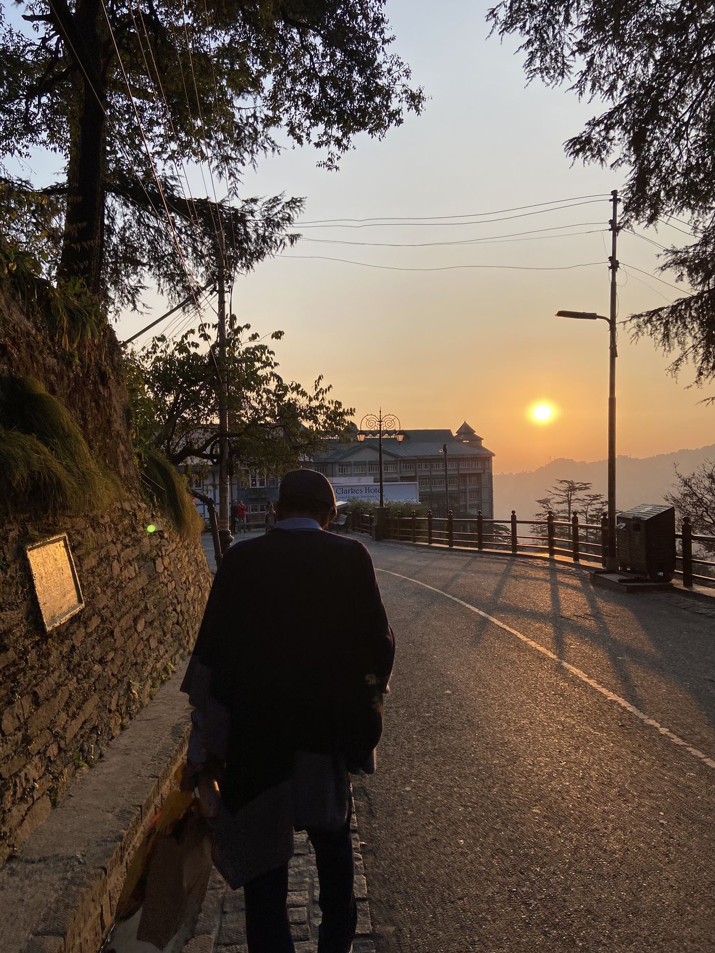 Rajiv Sachdev walking towards the sunset on a hill road in Shimla